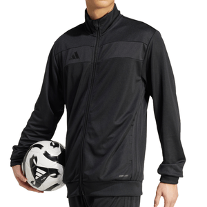 A person wearing a black Adidas tracksuit featuring the Aeroready logo holds a black and white soccer ball with the Adidas logo.