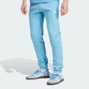 Light blue Adidas tracksuit pants and matching sneakers with white stripes and brown soles.