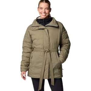 A woman wears a Columbia Belted Down Jacket in olive green, featuring a belted waist, asymmetrical zipper, and quilted design. The collar is high, and the jacket includes full-length sleeves and zippered side pockets.