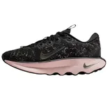 A black athletic shoe with speckled details, featuring a reflective Nike swoosh and a light pink sole.