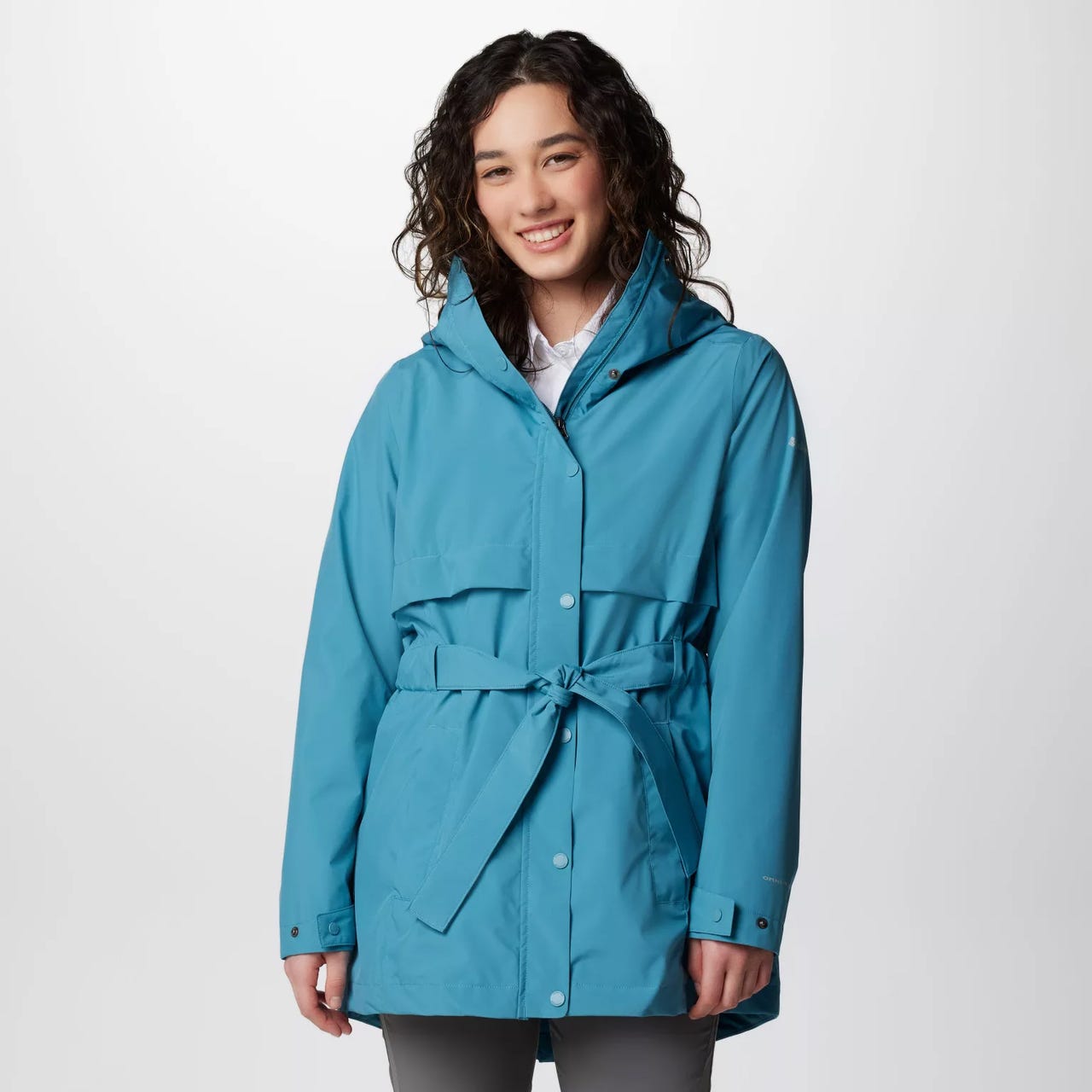 A woman is wearing a blue raincoat with a hood and a waist tie.