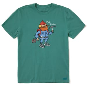 Green t-shirt featuring a cartoon character wearing winter gear, holding a pickaxe with the phrase \“Pick Kindness\“ above.