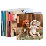Stack of customized photo books showing a cover with a baby and a dog wearing hats, dated May 2025.