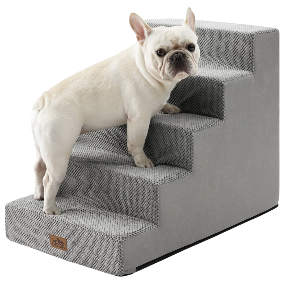 A small dog stands on gray pet stairs designed to assist animals in reaching higher areas, featuring a textured surface for grip.