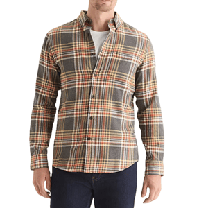 A man wears a plaid button-up flannel shirt in shades of gray, yellow, and orange, layered over a white T-shirt, paired with dark jeans.