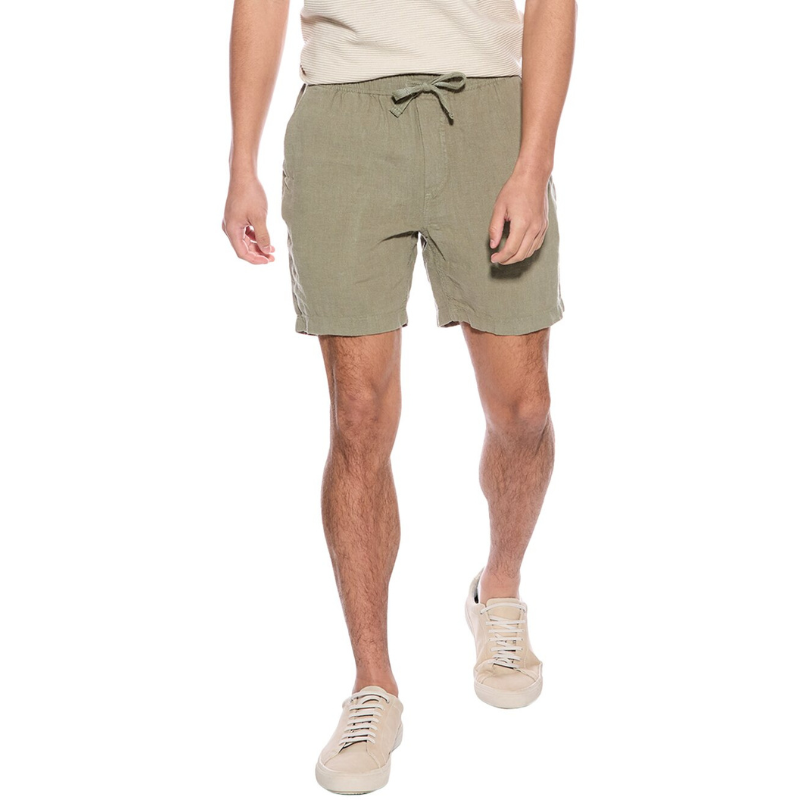 A pair of olive green linen shorts with an elastic waistband, drawstring closure, and side pockets, paired with beige casual sneakers.