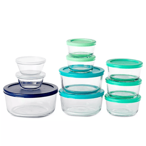 A set of glass storage containers with round and oval shapes, each featuring lids in various colors such as blue, teal, and green.