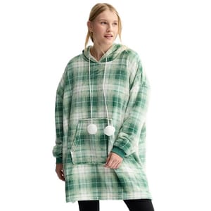 A woman is wearing an oversized hoodie with a green plaid pattern and pom-pom drawstrings.