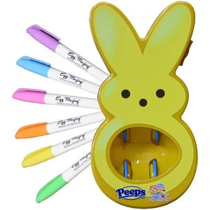 Eggmazing Egg Decorator Set includes a yellow bunny-shaped egg decorator and six vibrant markers in purple, blue, pink, orange, yellow, and green for creating colorful designs on eggs.