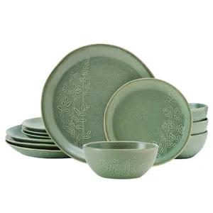 A green dinnerware set featuring plates and bowls with embossed floral patterns.