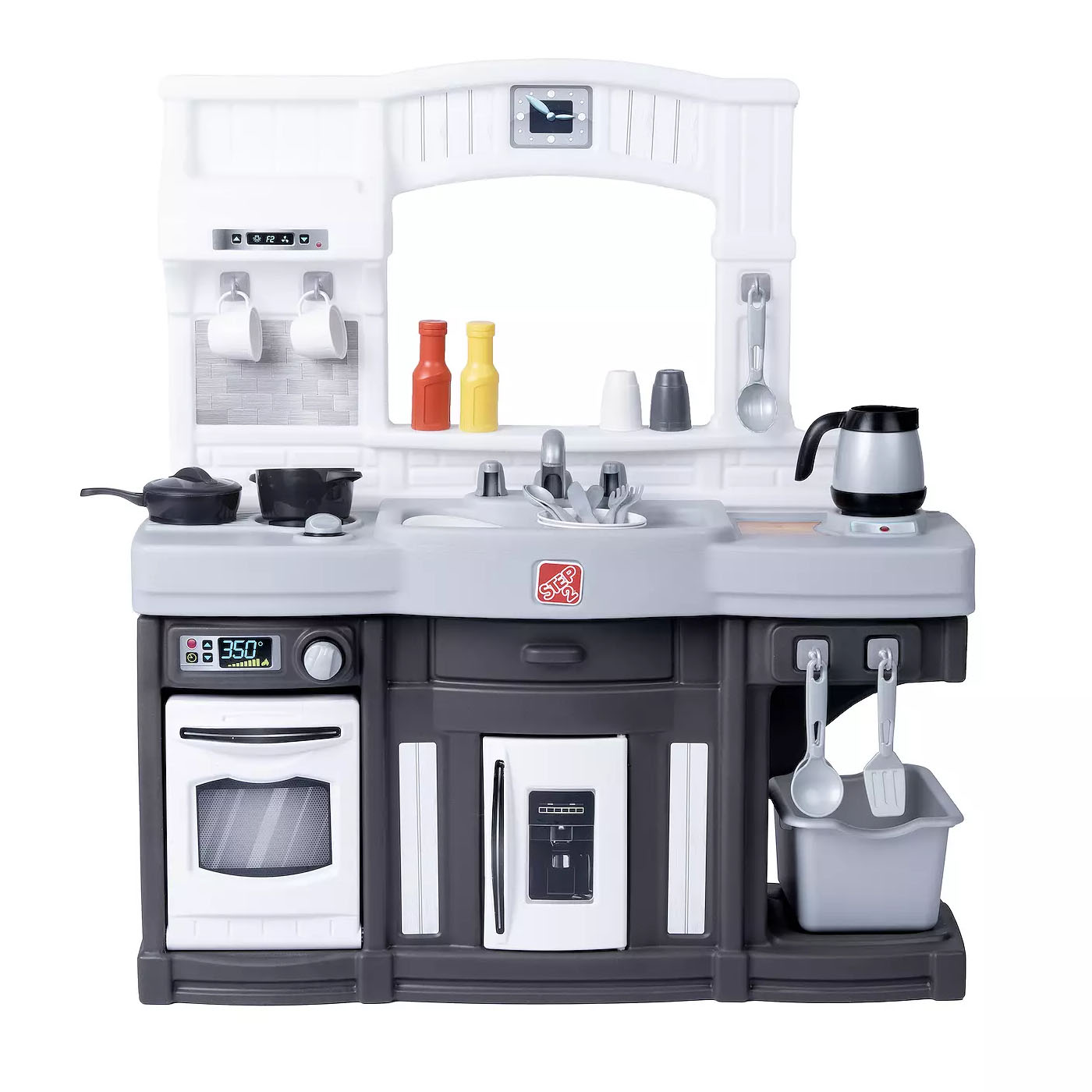 Step2 Modern Kitchen is a child-sized playset featuring a stove, oven, and sink with various accessories like pots, utensils, and condiment bottles. It includes a fridge and a coffee pot, with hooks for hanging utensils and a small bin for storage.