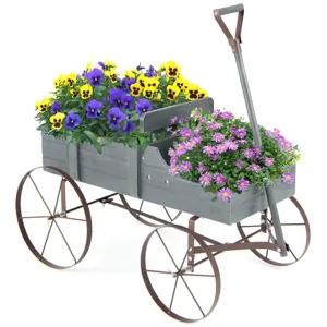 A decorative gray wooden cart with metal wheels, featuring yellow and purple pansies and pink daisy-like flowers, ideal for garden display.