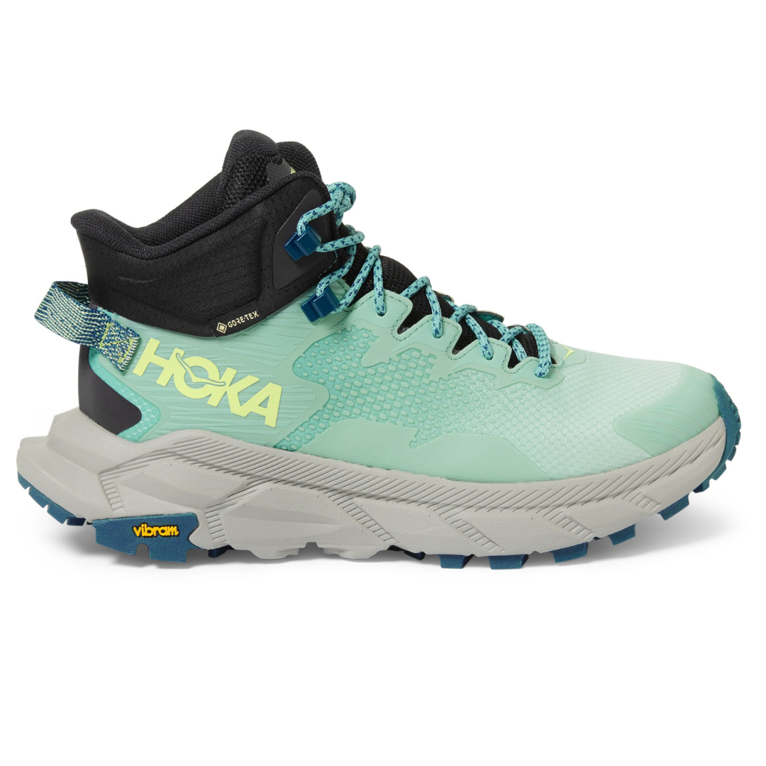 A teal and black hiking shoe with yellow HOKA branding and a Vibram sole.