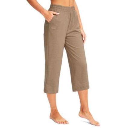 A person is wearing light brown, knee-length elastic waist pants with side pockets.