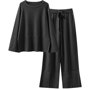 Black knit loungewear set with a loose long-sleeve top and drawstring wide-leg pants, featuring ribbed detailing at the cuffs and hem.