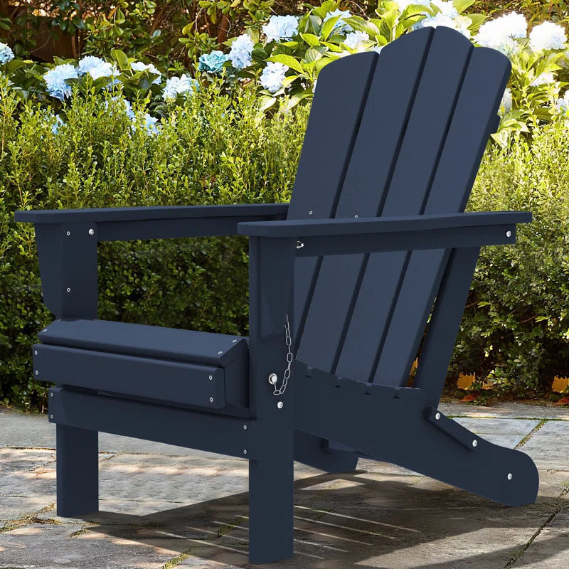 A navy blue Adirondack chair is shown in a garden setting, with green foliage and blooming hydrangeas in the background.