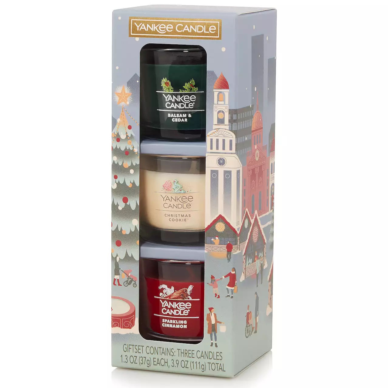 Mini Holiday Yankee Candle Set includes three scented candles: Balsam & Cedar, Christmas Cookie, and Sparkling Cinnamon, each weighing 1.3 oz (37g). The packaging features a festive winter cityscape design.