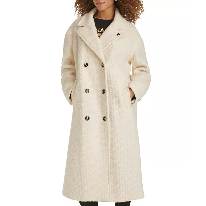 A cream-colored, double-breasted overcoat with a textured finish featuring six black buttons and side pockets, designed by Karl Lagerfeld.