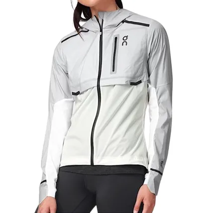 A gray and white athletic jacket with a hood and zip closure, featuring a chest pocket with the \“OC\“ logo, worn by a person with black leggings.