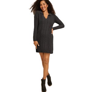 A dark gray, long-sleeve sweater dress with a cable knit design, featuring a V-neck and collar. Paired with black ankle boots, it offers a cozy and stylish look.