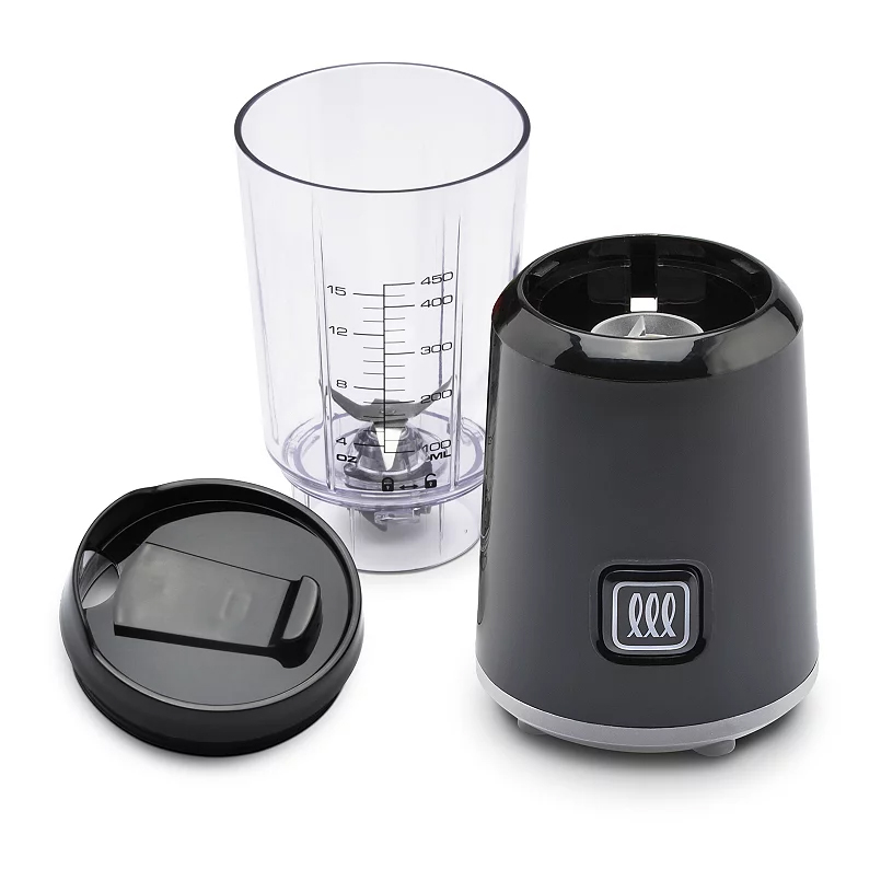 A compact blender with a transparent measuring cup, blade assembly, and a black motor base with control button. Includes a black lid designed for the cup.