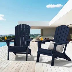 Two navy blue Adirondack chairs are placed on a wooden deck overlooking a modern patio, with drinks on the armrests.