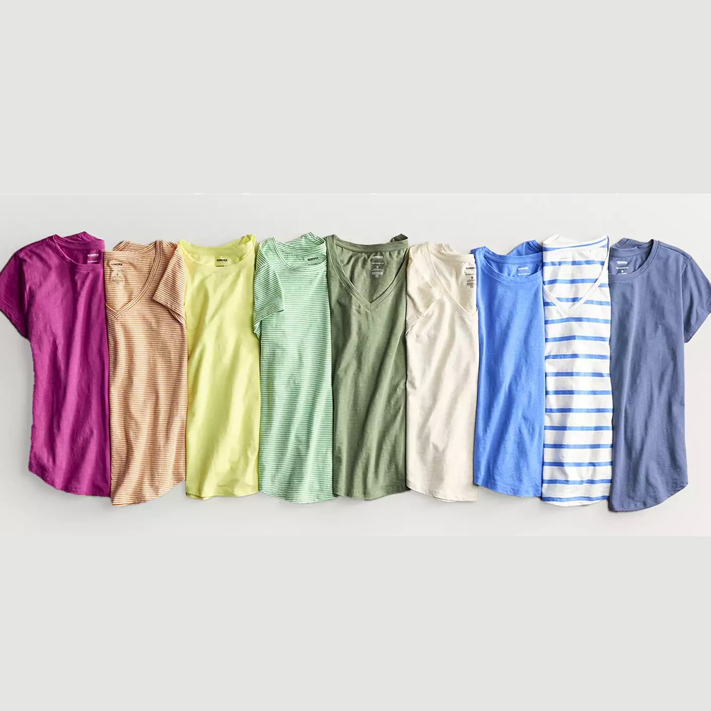 Seven assorted T-shirts in various colors and patterns displayed in a row.
