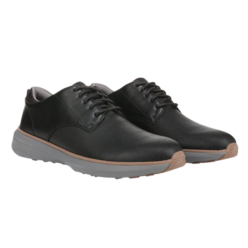 Pair of black lace-up shoes with textured uppers and gray soles, featuring a brown accent strip between the upper and sole.