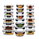 A set of stackable glass food storage containers with black locking lids, each filled with various foods like pancakes, vegetables, meatballs, and pasta.