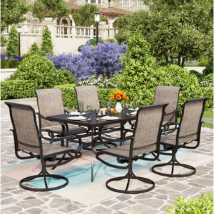 Outdoor patio set with six swivel chairs and a rectangular dining table, set on a stone patio surrounded by lush greenery and decorative plants.