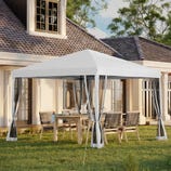 A white canopy tent with transparent curtains is set up in a backyard over a dining table and chairs, near a house with large windows and a tiled roof.