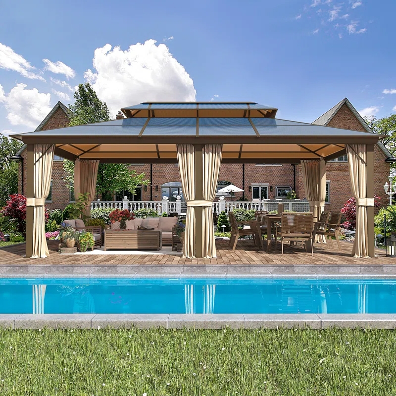 A stylish outdoor gazebo with curtains on a wooden deck beside a pool, featuring a lounge area with a sofa and a dining table with chairs.