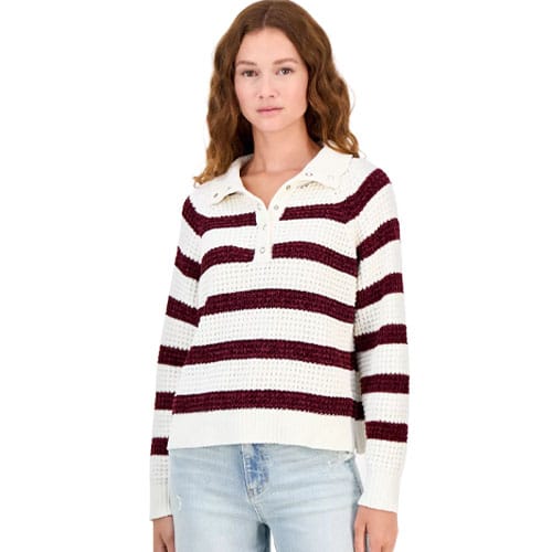 A woman wearing a white and burgundy striped collared sweater with buttons, paired with light blue jeans.