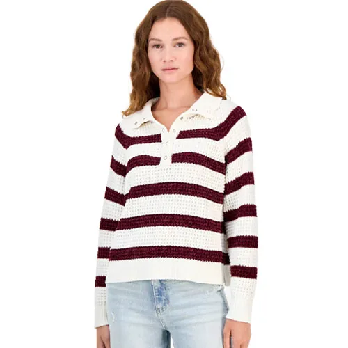 A woman wearing a white and burgundy striped collared sweater with buttons, paired with light blue jeans.