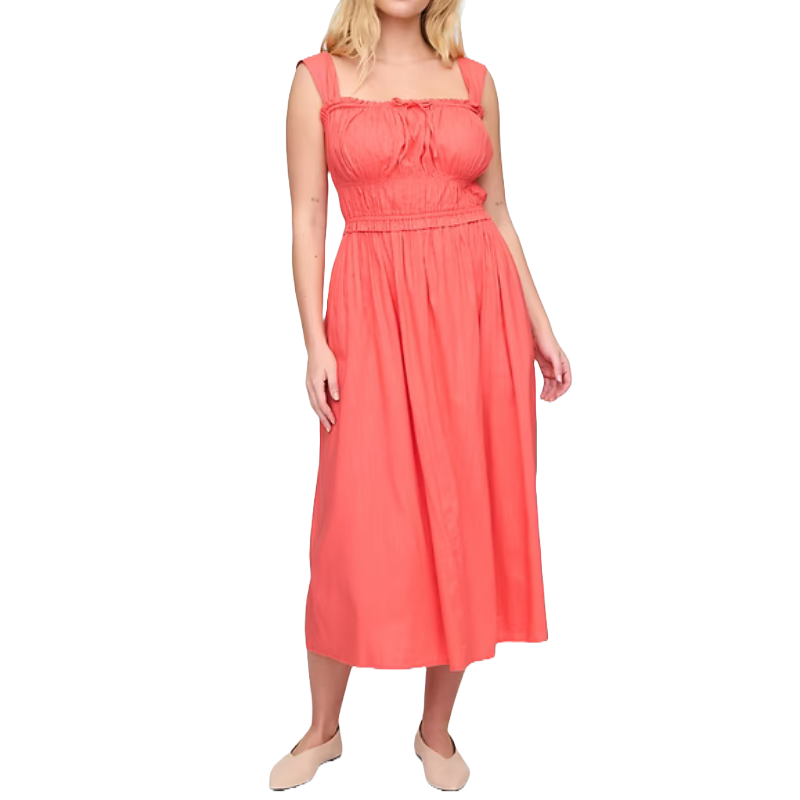 Coral smocked midi dress with wide shoulder straps, a fitted bodice, and a flowy skirt. Paired with nude slip-on shoes.