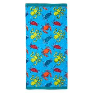 A bright blue beach towel featuring a pattern of yellow octopuses, red crabs, and blue turtles.