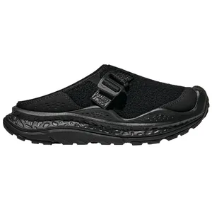 A black slip-on shoe featuring a chunky, textured sole and an adjustable strap, designed for comfort and support.