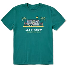 The Life is Good Let It Snow Tee is a green T-shirt featuring a graphic of a trailer, palm trees, flamingos, and a sun. It has a playful phrase that reads, \“Let It Snow Somewhere Else.\“