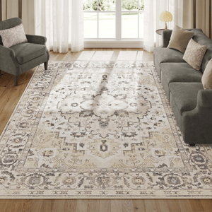 A traditional design 8' x 10' area rug featuring a central medallion with floral and geometric patterns in muted shades, surrounded by a detailed border; machine-washable with a soft texture, placed in a room with a gray sofa and an armchair.