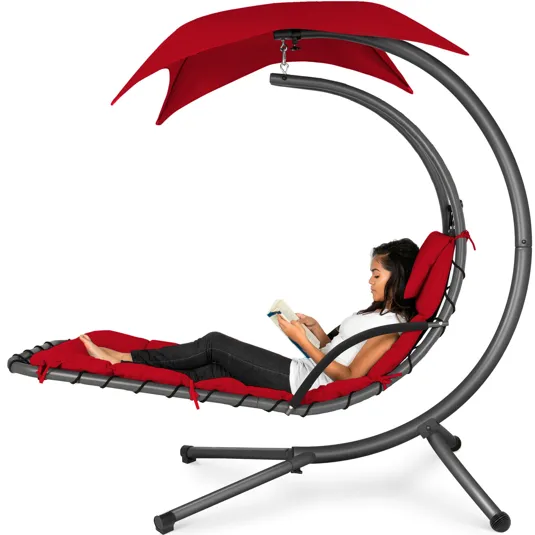 Curved outdoor hammock lounge with a red cushion and canopy, featuring a modern metal frame design.