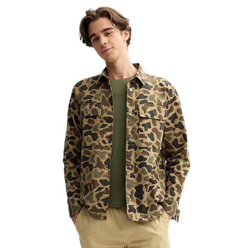 A man wearing a camouflage-patterned jacket over a green shirt and tan pants.