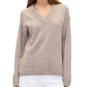 A beige V-neck sweater with ribbed cuffs and hem, paired with white trousers.