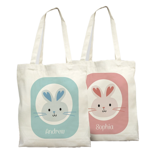 Two canvas tote bags with rabbit designs: a blue-eared rabbit with \“Andrew\“ and a pink-eared rabbit with \“Sophia,\“ each set against matching pastel backgrounds.