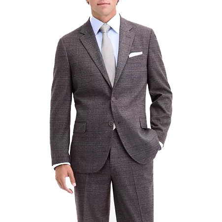 A man is wearing a brown plaid suit with a light blue shirt, a light gray tie, and a white pocket square, showcasing formal business attire.