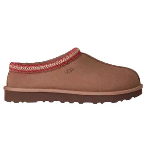 A brown slip-on shoe with a red and white patterned trim and rugged sole, featuring the UGG logo on the side.