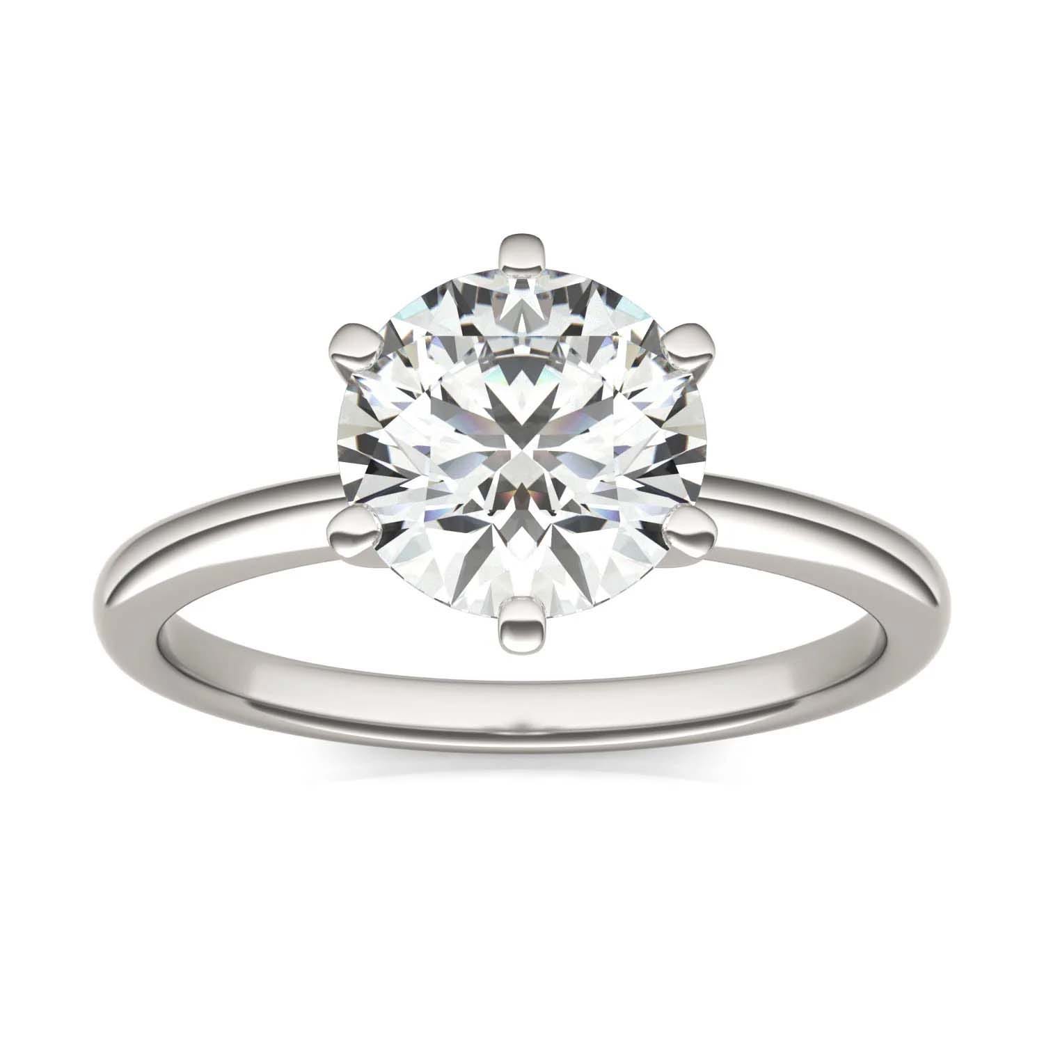 A silver ring featuring a round, solitaire diamond set in a six-prong setting with a simple band.