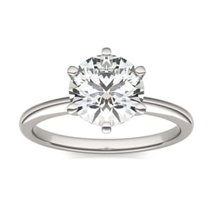 A silver ring featuring a round, solitaire diamond set in a six-prong setting with a simple band.