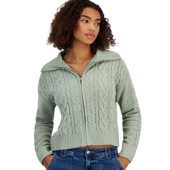 A sage green chenille cable-knit cardigan with a front zipper and large collar, featuring long sleeves and ribbed cuffs and hem, paired with blue jeans.