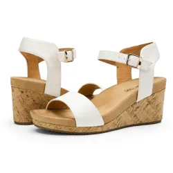 White wedge sandals with a cork platform, ankle straps, and buckle closures.