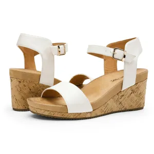 White wedge sandals with a cork platform, ankle straps, and buckle closures.